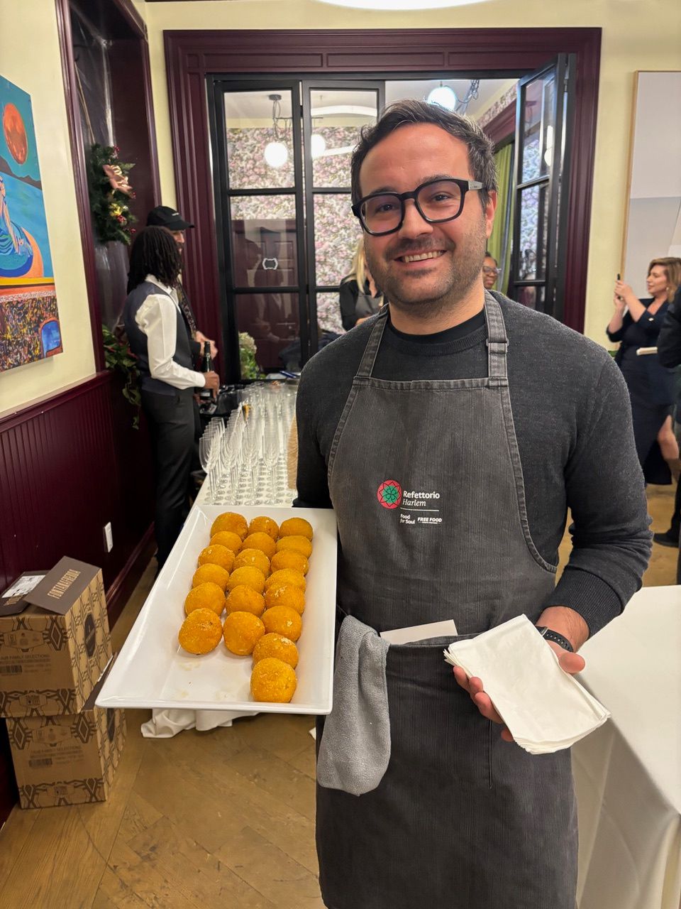 A server holding a tray of arancini.