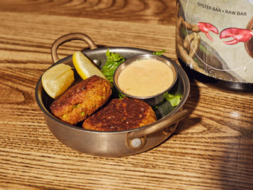 Crispy, pan-seared east coast crab cakes, paired with spicy mayo and lemon