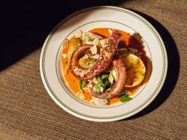Slowly-poached and oven-baked octopus is blowtorched to crispiness and served with fingerling potatoes. It’s finished with salsa verde and a house romesco